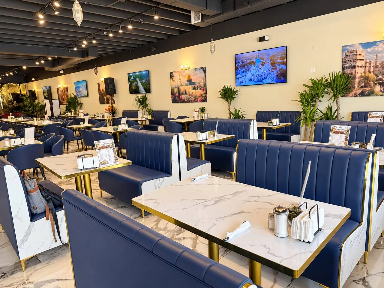 Blue booth seating and marble tables inside SimSim