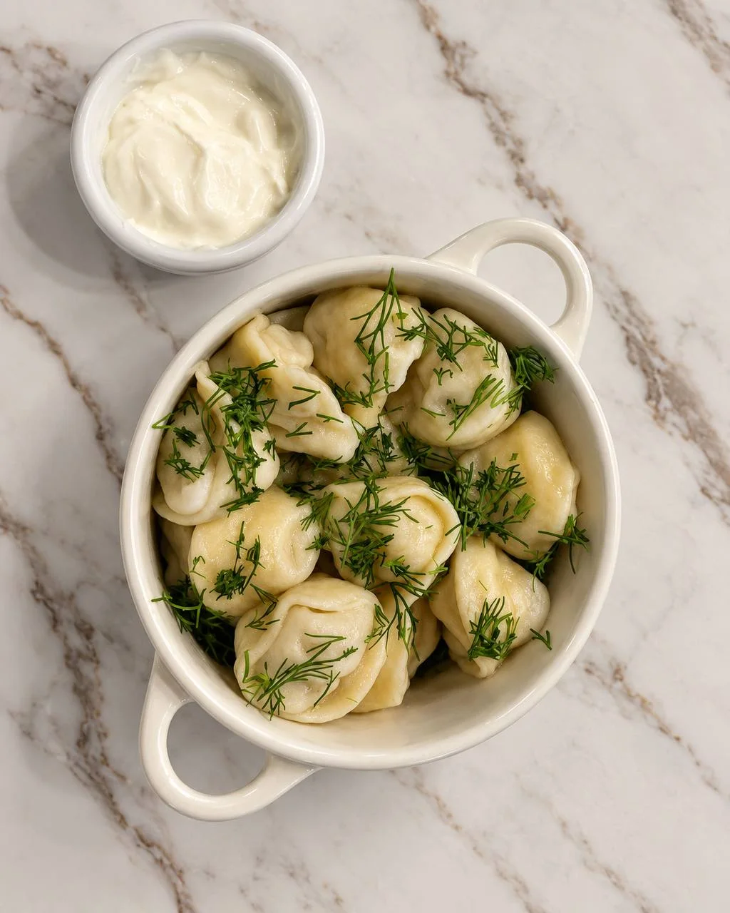 Ukrainian varenyky finished with fresh dill and served with sour cream